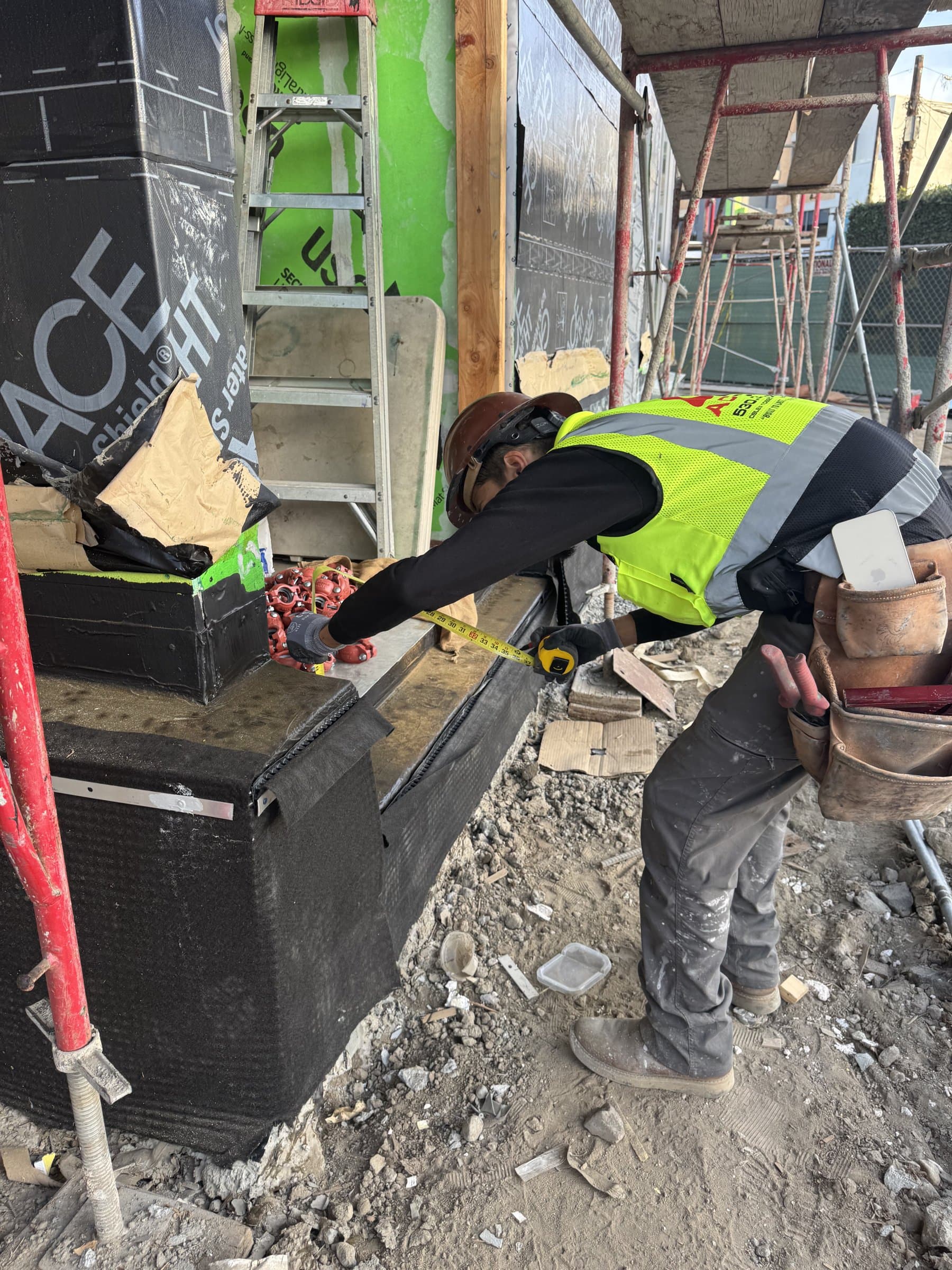 Worker applying a waterproofing membrane